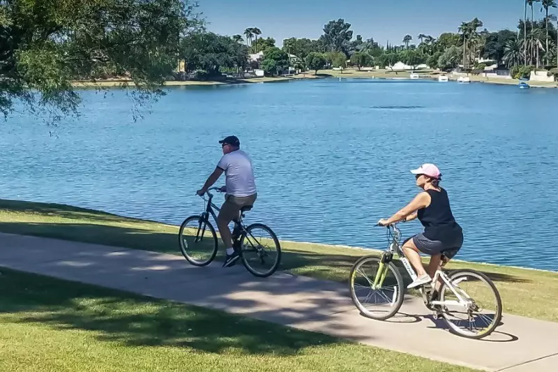 Two people cycling along a lakeside path at Inspire Day Spa Scottsdale