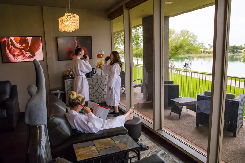 Inspire Day Spa interior lounge area with guests in robes overlooking a lakeside view